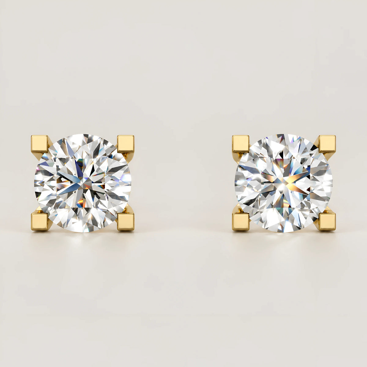 Solitaire diamant ørestikker i guld – set forfra med 4 kvadratiske grabber