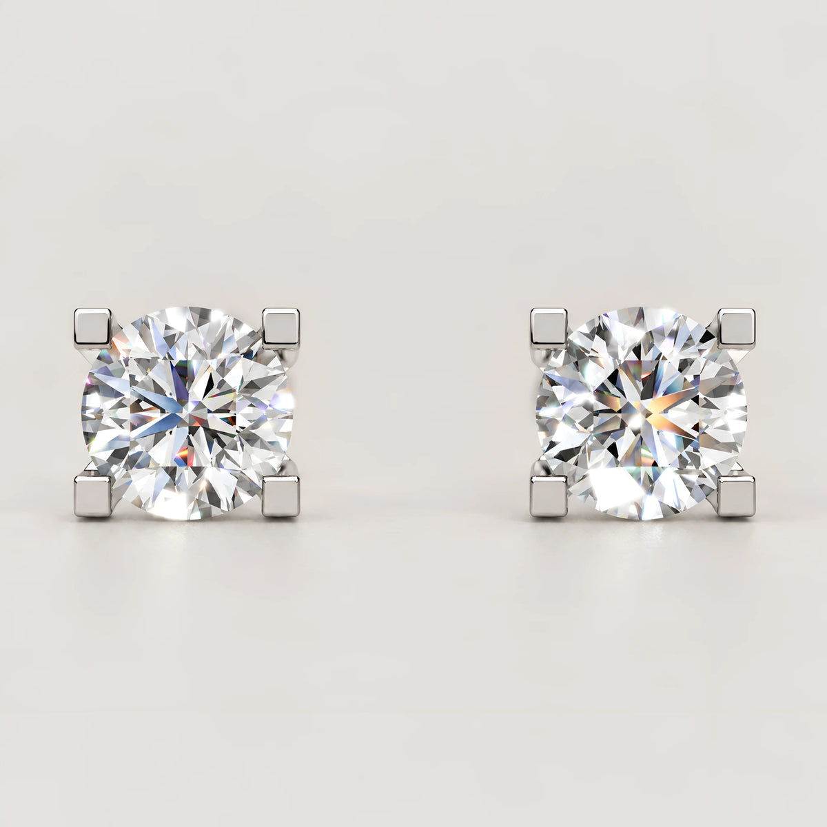 Solitaire diamant ørestikker i hvidguld – set forfra med 4 kvadratiske grabber