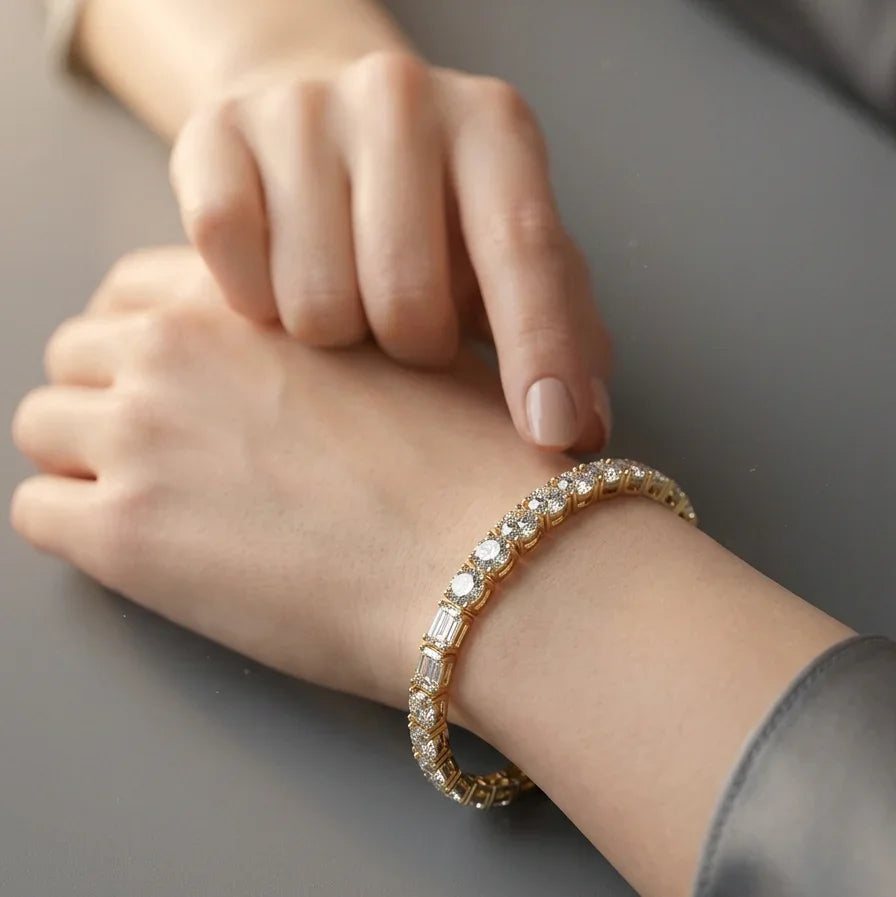 Diamant tennisarmbånd BR-20 båret på håndled i gulguld med emerald og round diamanter