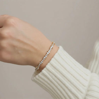 Pear and round lab grown diamond bracelet in 14k gold worn on hand
